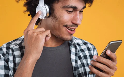 homem de fone aparenta ouvir música no celular