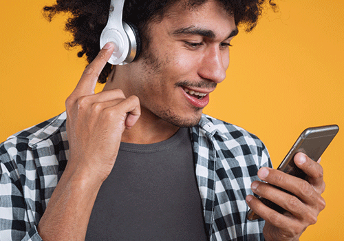 homem de fone aparenta ouvir música no celular